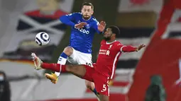 Gelandang Liverpool, Georginio Wijnaldum, berebut bola dengan pemain Everton, Gylfi Sigurdsson, pada laga Liga Inggris di Stadion Anfield, Minggu (21/2/2021). Everton menang 2-0 atas Liverpool. (Lawrence Griffiths/ Pool via AP)