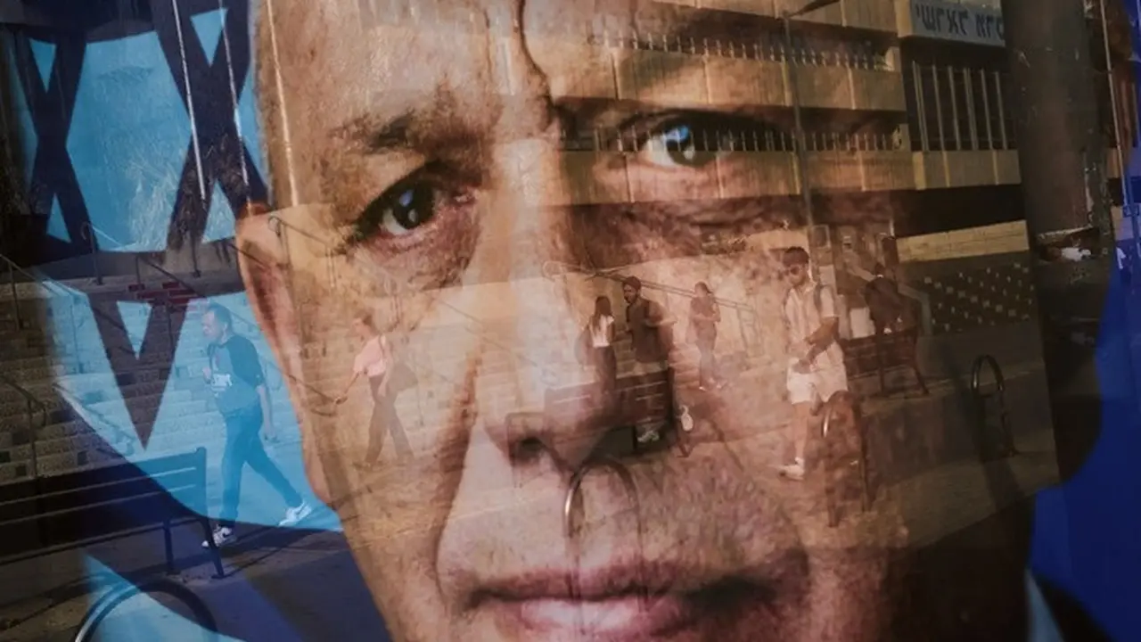 Bayangan sejumlah orang terpantul pada poster kampanye Gadi Eisenkot, pemimpin Partai Yashar yang berhaluan tengah, menjelang pemilihan umum Israel di Ramat Gan, Minggu (11/10/2026).