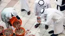 Seorang pria mengambil gambar udang selama pelelangan di pasar ikan di Kuwait City (8/8/2021). Pelelangan dibuka kembali di negara itu setelah enam bulan ditutup di tengah pandemi virus corona. (AFP/ Yasser Al-Zayyat)