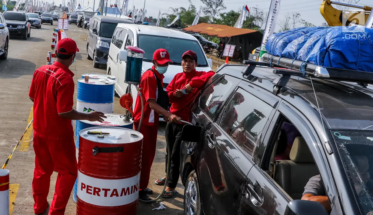 Petugas mengisi bahan bakar minyak (BBM) kendaraan di kios Pertamina tol fungsional (tol darurat) Brebes Timur-Gringsing, Tegal, Jawa Tengah, Jumat (30/6). PT Pertamina menjamin ketersedian BBM untuk arus balik aman. (Liputan6.com/Faizal Fanani)
