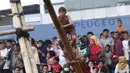 Ekspresi seorang anak saat mengikuti panjat pinang dalam Festival Kalimalang di Cipinang Melayu, Jakarta Timur, Kamis (17/8). Festival Kalimalang ini dalam rangka memeriahkan HUT ke-72 RI. (Liputan6.com/Herman Zakharia)