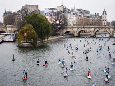 Peserta mendayung melewati aliran sunga- sungai selama perlombaan dayung dan perahu di Sungai Seine di Paris, Perancis, Minggu, (2/12). Acara ini diikuti oleh ribuan peserta dari berbagai kota di Paris. (AFP)