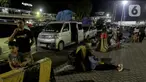 Aktivitas sejumlah pemudik saat sedang menunggu waktu masuk ke dalam kapal penyeberangan di Pelabuhan Merak, Banten, Jumat (28/3/2025). (Liputan6.com/Herman Zakharia)