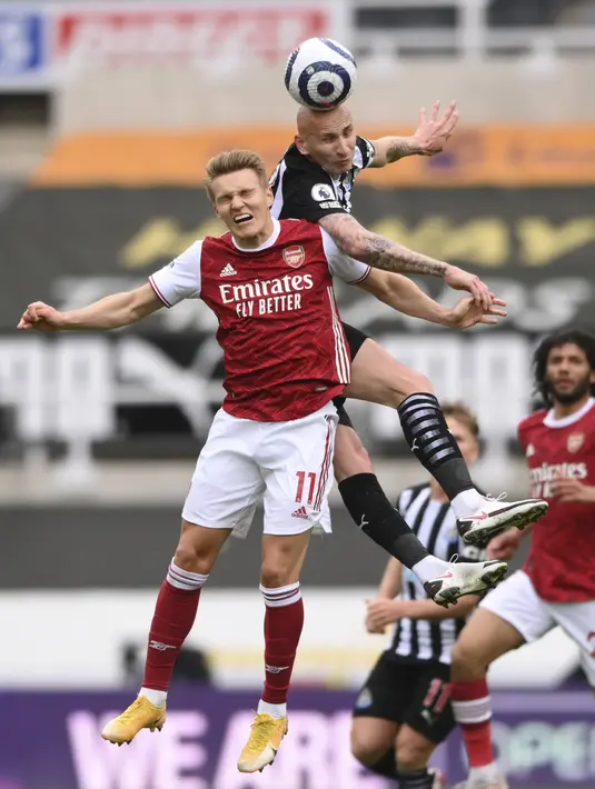Gelandang Arsenal, Martin Odegaard berebut bola udara dengan gelandang Newcastle United, Jonjo Shelvey pada pertandingan lanjutan Liga Inggris di stadion St James 'Park, di Newcastle, Inggris, Minggu (2/5/2021). Sementara Newcastle United kian terpuruk di peringkat ke-17. (Stu Forster/Pool via AP)