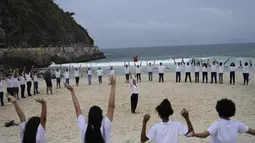 Orang-orang berkumpul di sepanjang pantai Copacabana pada Hari Laut Sedunia di Rio de Janeiro, Brasil, Rabu (8/9/2022). Organisasi Route Brasil menyerukan agar orang-orang berkumpul untuk acara yang diberi nama "Pelukan Itu," dan untuk memungut sampah di pantai, untuk menarik perhatian pada pencemaran laut. (AP Photo/Silvia Izquierdo)