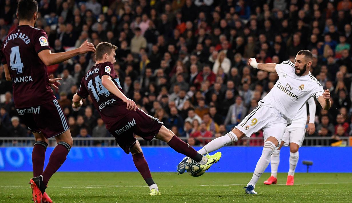 Penyerang Real Madrid, Karim Benzema berebut bola dengan Gelandang Celta Vigo, Filip Bradaric pada pertandingan lanjutan La Liga Spanyol di stadion Santiago Bernabeu di Madrid, Spanyol, Minggu, (16/2/2020). Madrid bermain imbang 2-2 atas Celta Vigo.  (AFP/Pierre-Philippe Marcou)