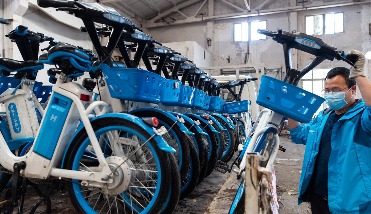 Seorang staf menempatkan sepeda listrik untuk layanan berbagi kendaraan ke dalam truk di sebuah gudang di Distrik Fancheng di Kota Xiangyang, Provinsi Hubei, China tengah (24/4/2020). (Xinhua/Xie Jianfei)