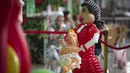 Pengunjung melintasi boneka yang terbuat dari balon saat acara International Festival of Air Balloons Design, Almaty, Kazakhstan, 9 Juli 2015. Karya seni yang ditampilkan di acara tersebut seluruhnya terbuat dari balon. (REUTERS/Shamil Zhumatov)