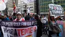 Seorang demonstran memperlihatkan spanduk bertuliskan “Keluarkan Temer!” dalam unjuk rasa di Sao Paulo, Brasil, Rabu (2/8). Aksi ini berlangsung di beberapa negara bagian Brasil dan sekitar ratusan orang terlibat dalam protes tersebut (AP/Andre Penner)