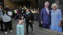 Wisatawan melewati potret besar Raja Charles III dan Ratu Camilla  yang dipajang di Stasiun Kings Cross di London, Senin, 1 Mei 2023. Penobatan Raja Charles III akan berlangsung di Westminster Abbey pada 6 Mei. (AP Photo/Kirsty Wigglesworth)