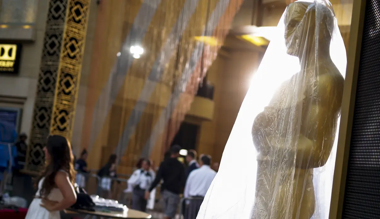 Seorang wanita berpose di dekat patung Oscar 2016 di luar Teater Dolby, Hollywood, California, Sabtu (27/2). Acara penghargaan Academy Awards ke-88 ini akan berlangsung pada Minggu (28/2) waktu setempat. (REUTERS/Adrees Latif)