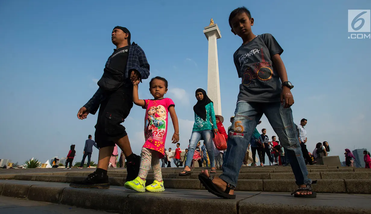 Sejumlah pengunjung berjalan-jalan di kawasan Monumen Nasional (Monas) Jakarta, Kamis (6/6/2019). Monas yang merupakan Ikon Ibu Kota itu menjadi salah satu tujuan wisata untuk mengisi libur Lebaran. (merdeka.com/Imam Buhori)