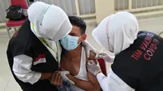 Reaksi seorang siswa SMA saat menerima dosis vaksin virus corona COVID-19 Pfizer di Rumah Sakit Zainoel Abidin, Banda Aceh, Aceh, Selasa (9/11/2021). Vaksinasi COVID-19 di kalangan warga Kota Banda Aceh tembus 80 persen. (CHAIDEER MAHYUDDIN/AFP)