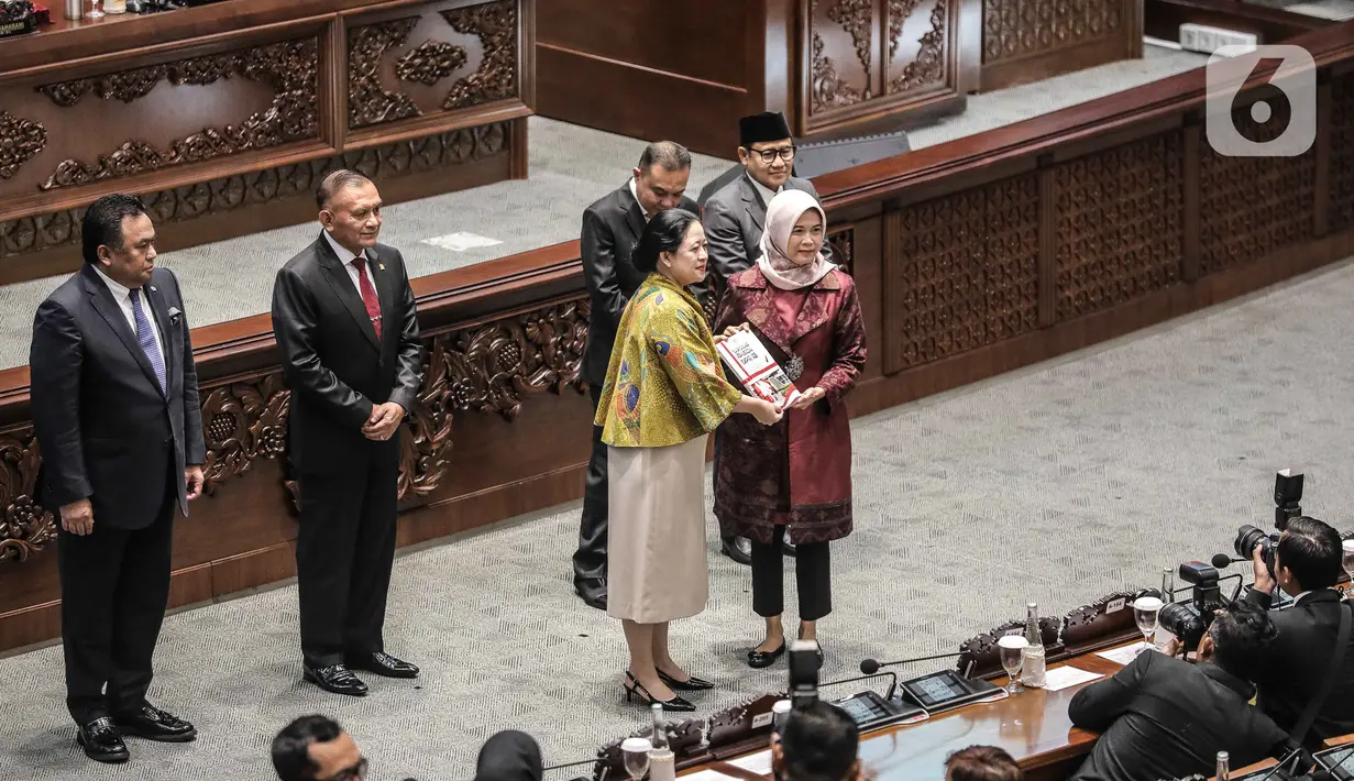 Ketua DPR Puan Maharani (kiri) menyerahkan  menyampaikan buku laporan kinerja DPR kepada ke ketua BPK RI Isma Yatun dalam rapat paripurna memperingati HUT ke-78 DPR RI di kompleks Parlemen, Senayan, Jakarta, Selasa (29/8/2023). (Liputan6.com/Faizal Fanani)