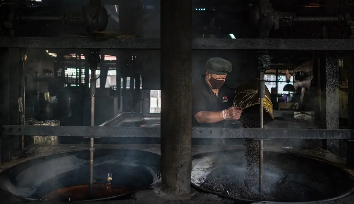 Pekerja memanggang biji kopi di Pabrik Kopi Antong, Taiping, Perak, Malaysia, 29 September 2020. Pabrik Kopi Antong menggunakan mesin antik dan metode pemanggangan tradisional untuk menghasilkan bubuk sarat kafein yang terkenal selama 87 tahun. (Mohd RASFAN/AFP)