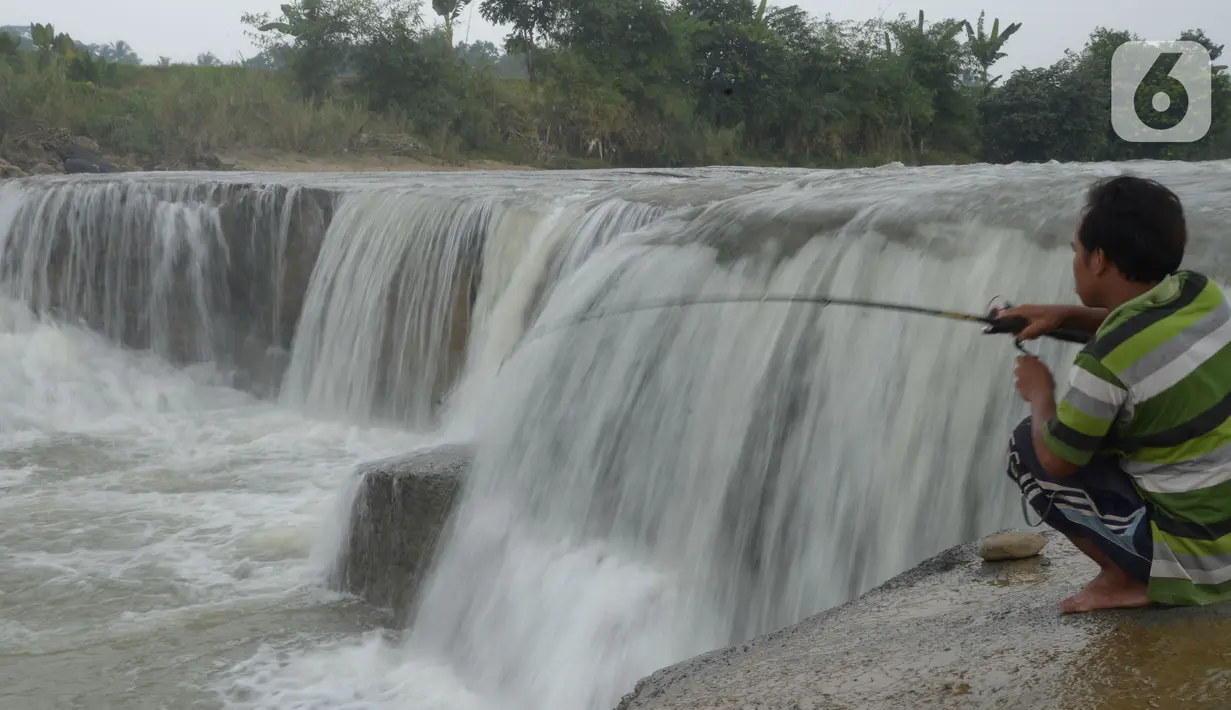 Warga memancing ikan di sungai Cileungsi, Pasir Mukti, Jawa Barat, Sabtu (29/5/2021).  Mencari ikan dengan alat pancing seadanya merupakan cara warga di sekitar Sungai Cileungsi untuk mengisi kekosongan waktu. (merdeka.com/Imam Buhori)