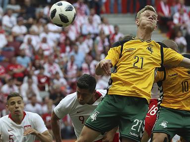 Duel pemain Polandia, Robert Lewandowski dengan pemain Lituania, Justas Lasickas pada laga uji coba di Stadion Narodowy, Warsaw, Polandia, (12/6/2018). Polandia menang 4-0. (AP/Czarek Sokolowski)