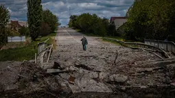Prajurit unit pasukan khusus Ukraina Kraken berbicara dengan seorang pria di jembatan yang hancur di jalan dekat desa Rus'ka Lozova, utara Kharkiv, pada 16 Mei 2022. Ukraina mengatakan pasukannya telah menguasai kembali wilayah di Perbatasan Rusia dekat kota terbesar kedua di negara itu Kharkiv, yang terus-menerus diserang sejak invasi Moskow dimulai. (Dimitar DILKOFF / AFP)