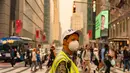 Pengunjung Times Square di New York tampak tidak terganggu oleh asap kebakaran hutan pekat yang menyelimuti area tersebut pada hari Rabu, 7 Juni.  (David Dee Delgado/Getty Images/AFP)