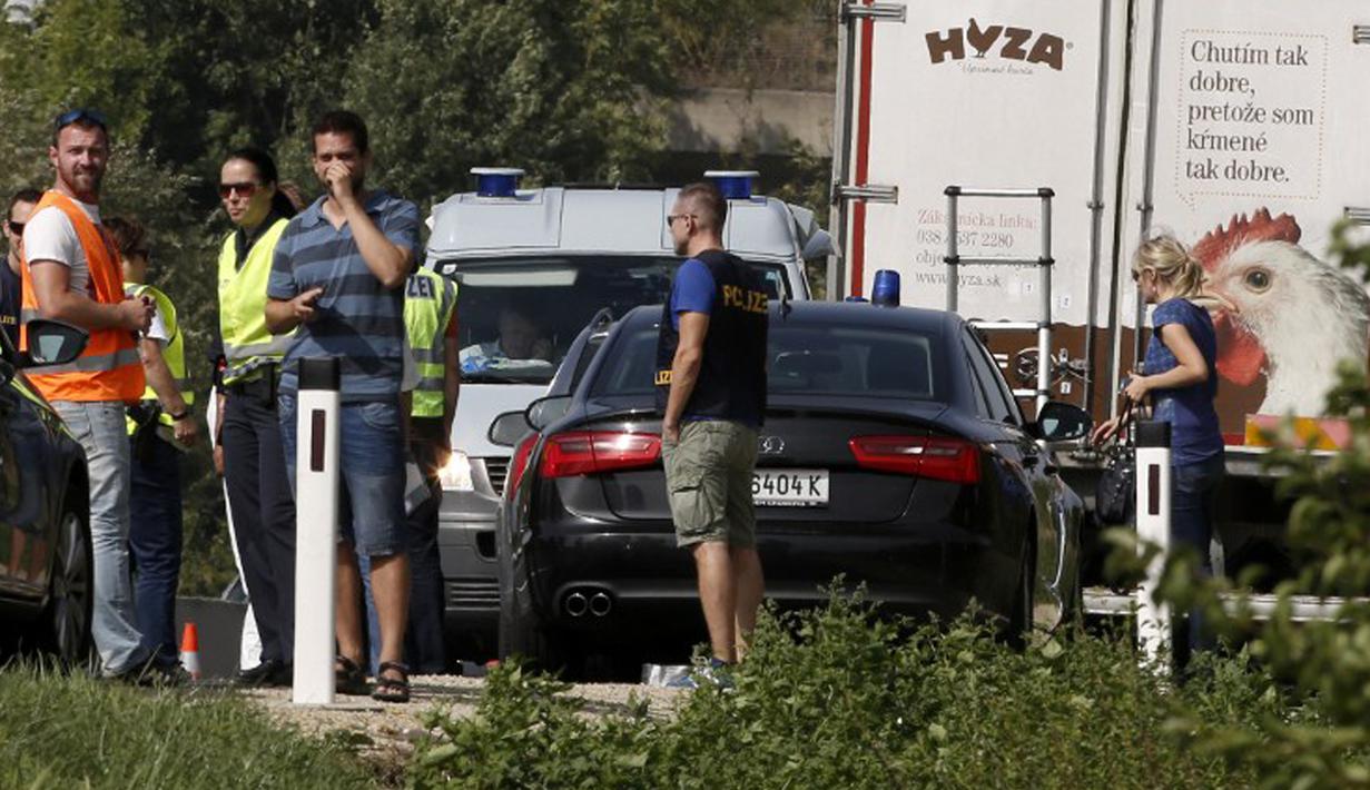 Polisi berada di lokasi dimana sebuah truk yang berisi sekitar 50 imigran gelap yang tewas terparkir di jalan tol di Austria, dekat perbatasan Hongaria, Kamis (27/8/2015). Indikasi awal mereka tewas karena kekurangan oksigen. (AFP PHOTO/Dieter NAGL)