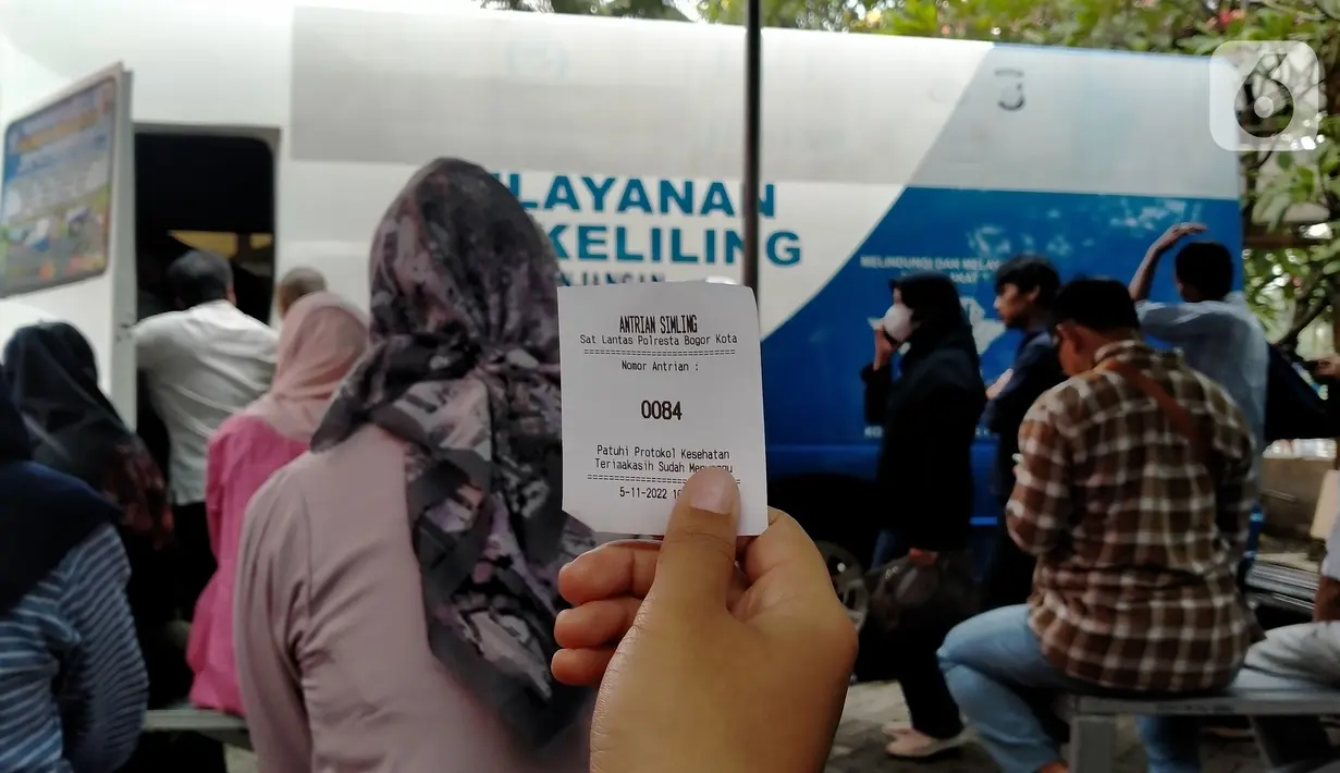 Warga menunjukkan nomor antrean selama proses perpanjang SIM A dan SIM C saat Pelayanan SIM Keliling di Plaza Jambu Dua, Kota Bogor, Sabtu (5/11/2022). Polresta Bogor Kota telah mempersiapkan beberapa titik lokasi pelayanan di wilayah Kota Bogor, warga hanya perlu membawa SIM A/C asli yang hendak diperpanjang masa berlakunya dan menyertakan fotocopy E-KTP. (Liputan6.com/Magang/Aida Nuralifa)