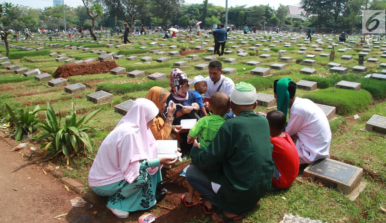 Warga berdoa saat berziarah di TPU Karet Pasar Baru Barat, Jakarta, Sabtu (16/6). Ziarah kubur atau "nyekar" pada hari raya lebaran merupakan salah satu tradisi umat muslim untuk mendoakan sanak keluarga yang meninggal dunia. (Liputan6.com/Arya Manggala)