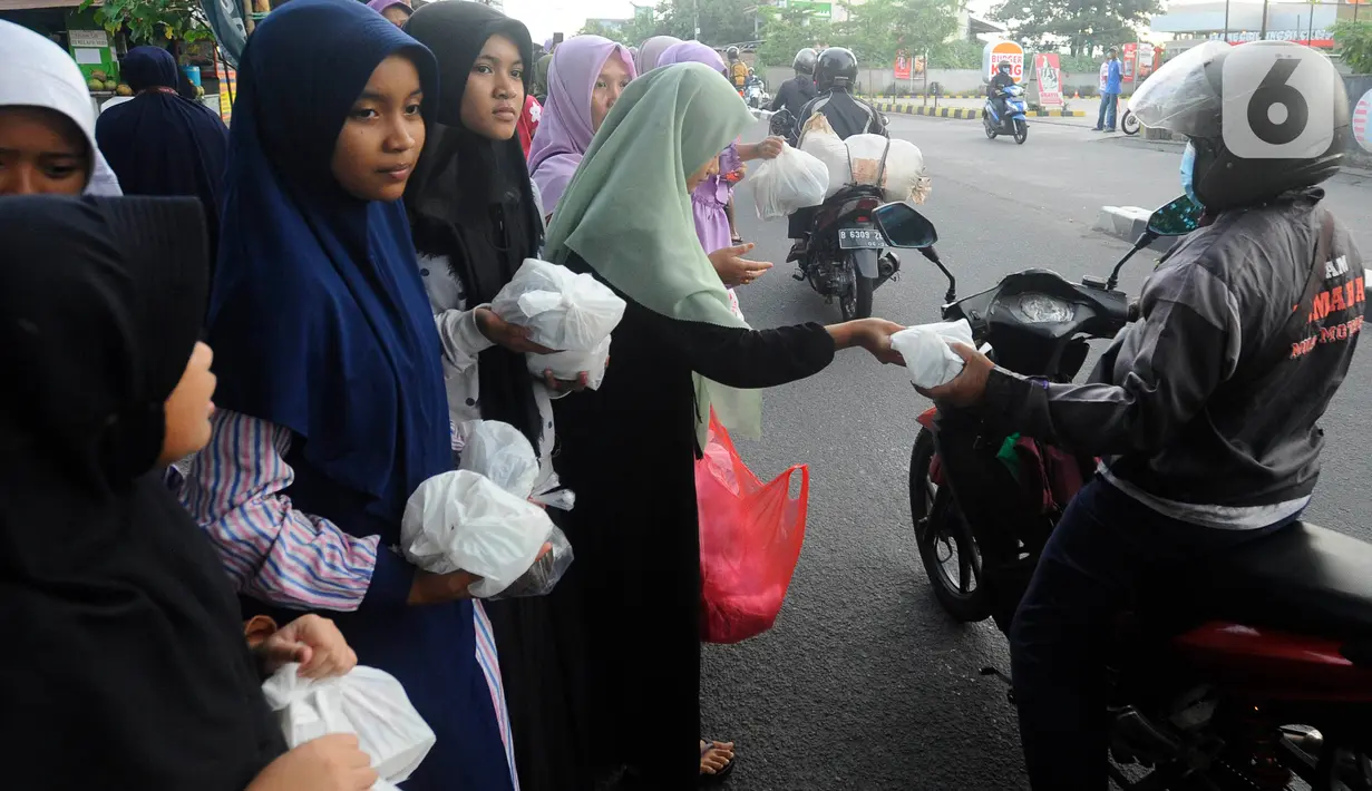 Sambil membawa bingkisan takjil. Anak-anak sangat antusias membagikan takjil pada para pengendara. (merdeka.com/Arie Basuki)