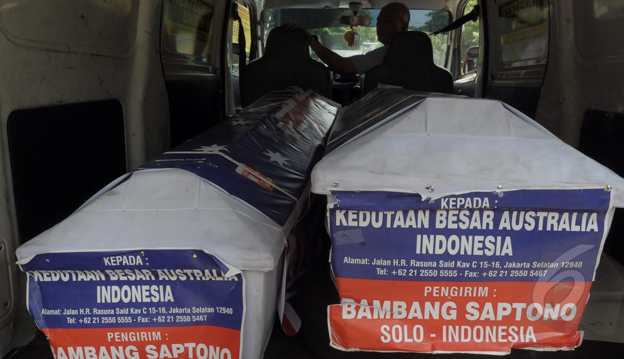 Petugas Kantor Pos mengirimkan dua peti mati ke kantor Kedutaan Besar Australia untuk Indonesia di Rasuna Said, Jakarta, Senin (9/3/2015).  Tampak, dua peti mati kiriman Bambang Saptono saat masih berada di dalam mobil. (Liputan6.com/Andrian M Tunay)