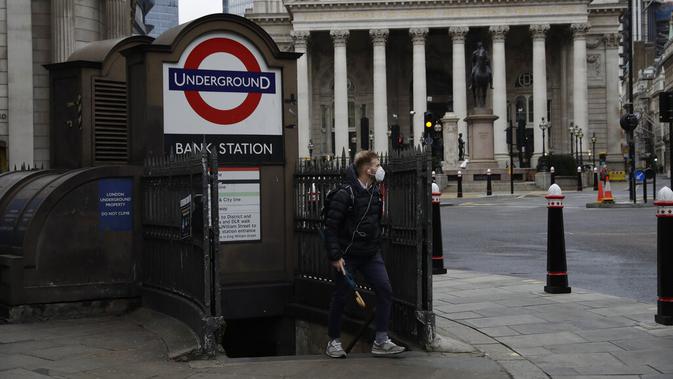 Seorang pria berjalan keluar dari stasiun kereta bawah tanah pada pagi pertama penerapan lockdown nasional ketiga di Kota London, Inggris, 5 Januari 2021. Inggris memasuki lockdown nasional ketiga sejak pandemi virus corona COVID-19 dimulai. (AP Photo/Matt Dunham)