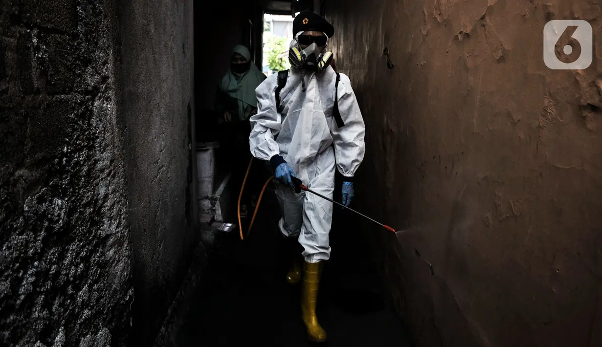 Petugas Palang Merah Indonesia (PMI) Jakarta Timur berpakaian APD menyemprotkan disinfektan di permukiman Kampung Tengah, Kramat Jati, Minggu (23/8/2020). Penyemprotan sebagai langkah sterilisasi permukiman setelah warga di Kampung Tengah dilaporkan terpapar Covid-19. (Liputan6.com/Iqbal Nugroho)