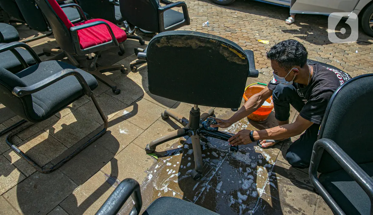 Karyawan membersihkan peralatan kantor pascabanjir di salah satu bank swasta di Kemang, Jakarta, Selasa (23/2/2021). Karyawan pertokoan, perkantoran, hingga perbankan mulai membersihkan sisa lumpur dari banjir yang melanda kawasan tersebut pada 20 Februari 2021 lalu. (Liputan6.com/Faizal Fanani)