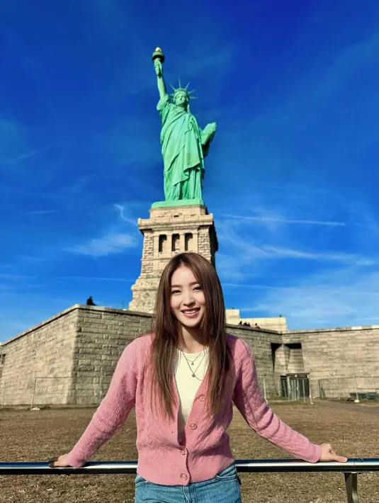 Berpose di depan patung Liberty yang ikonik, Natasha Wilona tampil kece dengan outfit kasual. Ia memadukan kaus putih dengan cardigan pink dan celana jeans. [@natashawilona12]
