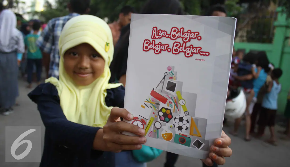 Seorang bocah memperlihatkan buku tulis yang ia peroleh dari Presiden Jokowi, Jakarta, Kamis (3/9/2015). Presiden Jokowi bersama Gubernur Ahok mengadakan blusukan dan membagikan semabko pada warga di kawasan Cilincing. (Liputan6.com/Gempur M Surya)