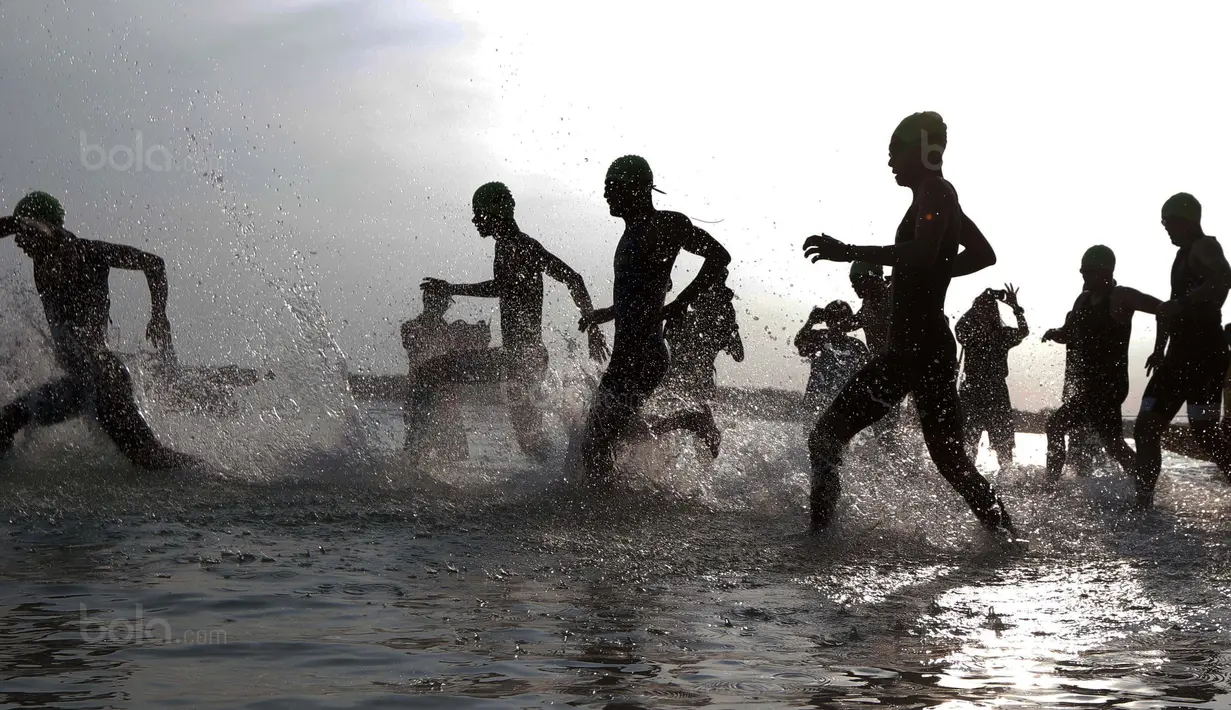 Para atlet Rhino Cross Triathlon berebut masuk air pada Festival Pesona Tanjung Lesung 2017 di Tanjung Lesung, Banten (24/9/2017). Total jarak tempuh Rhino Cross Triathlon 38 km. (Bola.com/Nicklas Hanoatubun)