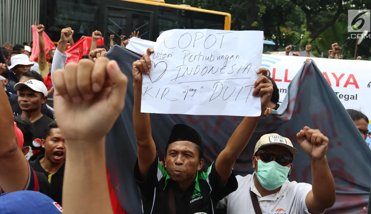 Sejumlah demonstran membawa poster saat menggelar aksi di depan Kantor Kementrian Perhubungan, Jakarta Pusat, Senin (29/1). Permenhub tersebut  soal Kendaraan Bermotor Umum Tidak Dalam Trayek. (Liputan6.com/Angga Yuniar)