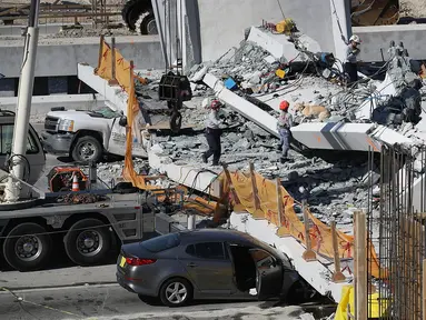 Tim Penyelamatan Kebakaran Miami-Dade Fire dan unit penyelamatan lainnya berusaha mengevakuasi korban runtuhnya jembatan pejalan kaki di Miami, Florida (15/3). Beberapa orang dilaporkan tewas dalam insiden ini. (Joe Raedle / Getty Images / AFP)