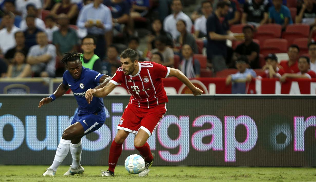 Gelandang Bayern Munchen, Javi Martinez, berebut bola dengan striker Chelsea, Michy Batshuayi pada laga turnamen pramusim ICC 2017 di Stadion Nasional Singapura, Selasa (25/7/2017). Bayern Munchen menang 3-2 atas Chelsea. (EPA/Wallace Woon)