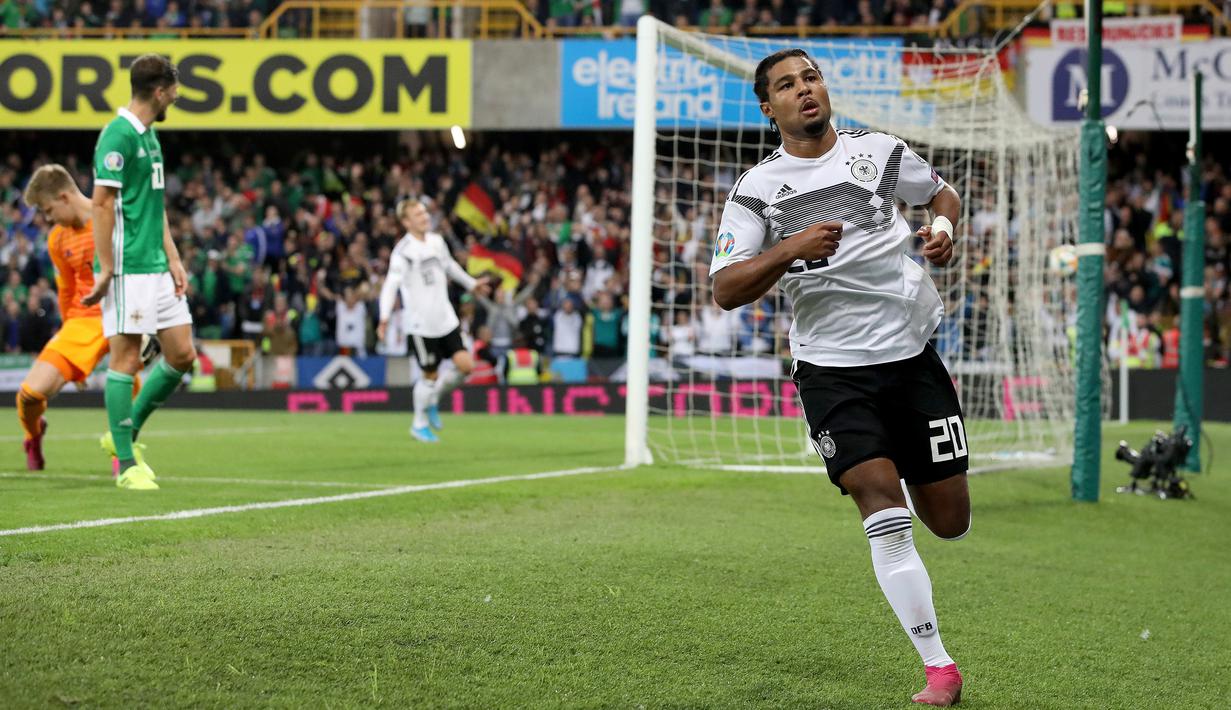 Gelandang Jerman, Serge Gnabry melakukan selebrasi usai mencetak gol ke gawang Irlandia Utara dalam kualifikasi Euro 2020 di Windsor Park, Belfast, Senin (9/9/2019). Jerman berhasil merebut puncak klasemen grup C kualifikasi Euro 2020 usai mengalahkan Irlandia Utara 2-0. (Paul Faith/AFP)