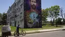 Mural Lionel Messi sebuah bangunan di dekat bekas sekolah dasar di Rosario, Argentina, Rabu (14/12/2022). (AP Photo/Rodrigo Abd)