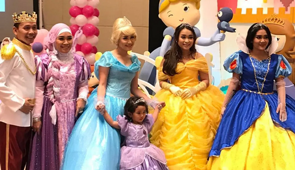 Bilqis mengenakan kostum Princess Sophia warna ungu. Dan Ayu mengenakan kostum Cinderella. Begitu juga dengan orangtua serta adiknya berdandan layaknya di negeri dongeng. (Instagram/bilqis3rdbirthday)