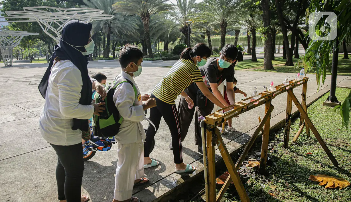Sejumlah pengunjung mencuci tangan di Lapangan Banteng, Jakarta, Sabtu (23/10/2021). Pembukaan 59 RTH ini menyusul penurunan status Pemberlakuan Pembatasan Kegiatan Masyarakat atau PPKM Jakarta yang kini berada di level dua. (Liputan6.com/Faizal Fanani)