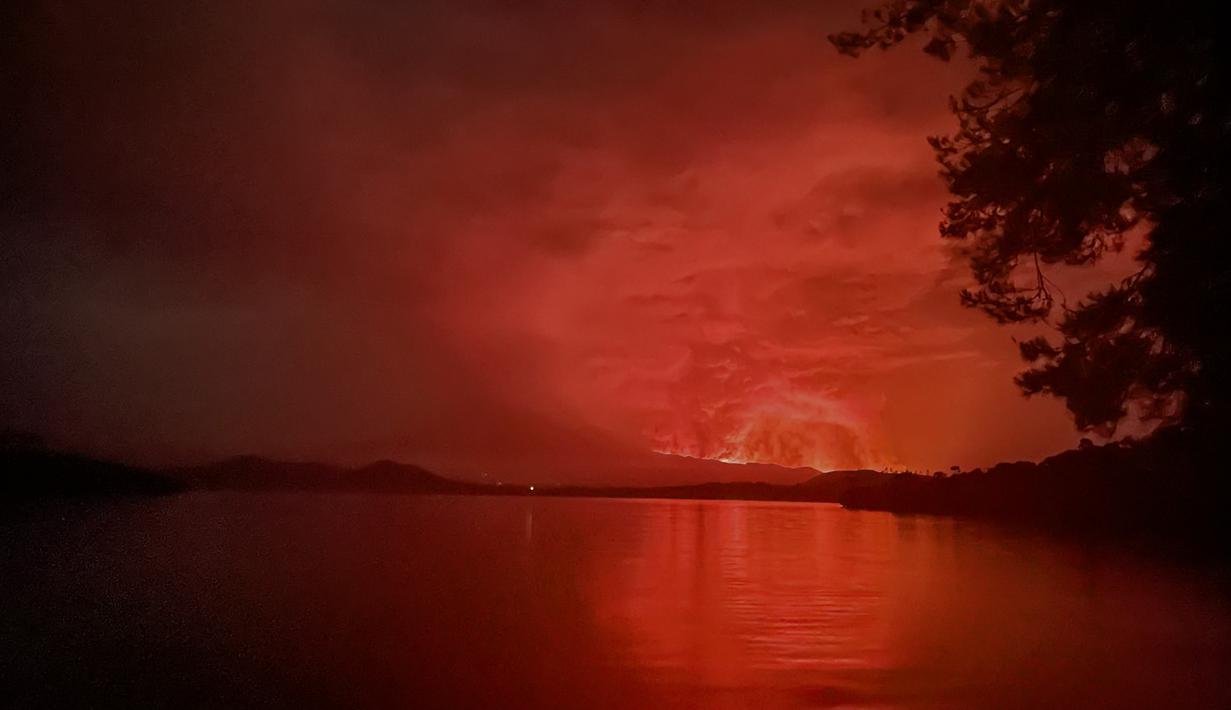 Pemandangan pada 22 Mei 2021 dari Pulau Tchegera di luar Goma di danau Kivu di sebelah timur Republik Demokratik Kongo menunjukkan semburan api dari gunung berapi Nyiragongo. Misi PBB ke RD Kongo sebelumnya mengirim helikopter "di atas zona itu dan mengonfirmasi letusan tersebut." (Alex Miles/AFP)