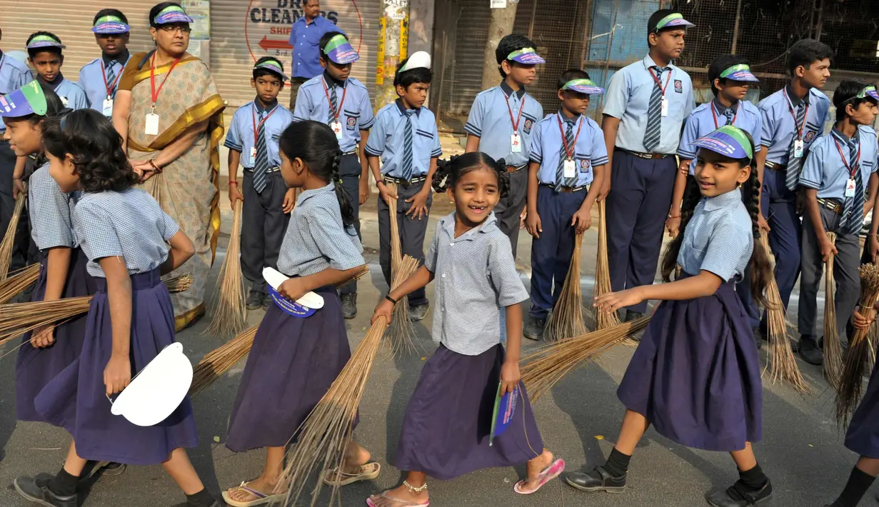 Sejumlah pelajar India membawa sapu saat mengambil bagian dalam 'Swachh Bharat Abhiyan' atau kampanye kebersihan di Hyderabad (12/2). Kampanye ini bertujuan untuk membersihkan jalanan dan infrastruktur di kota-kota India. (AFP Photo/Noah Seelam)
