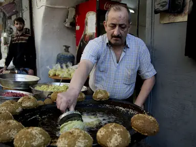 Pedagang membuat kudapan Falafel untuk menu berbuka puasa selama Ramadan di Kota Nablus, Tepi Barat, Minggu (26/4/2020). (AP Photo/Majdi Mohammed)