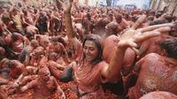 Para peserta saling melempar tomat dalam festival perang tomat tahunan "Tomatina" di desa Bunol dekat Valencia, Spanyol, Rabu, 27 Agustus 2025. (Dok. AP/Alberto Saiz)