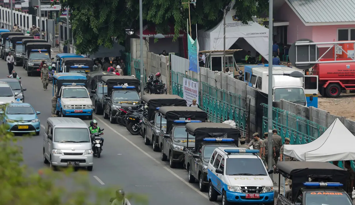 Petugas Satpol PP berjaga di trotoar Jalan Stasiun Senen, Pasar Senen, Jakarta, Rabu (11/12/2019). Pemerintah berencana merelokasi para PKL ke Pasar Metro Atom di kawasan Pasar Baru. (Liputan6.com/Faizal Fanani)