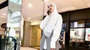 Selalu menarik untuk melihat potret OOTD Inara Rusli. Kali ini ia tampil mengenakan kemeja putih wanita modern, dengan lilitan obi bergaris, dipadu pleats skirt berwarna abu-abu, heels boots, hijab, dan tas tangan berwarna putih. [Foto: Instagram/mommy_starla]