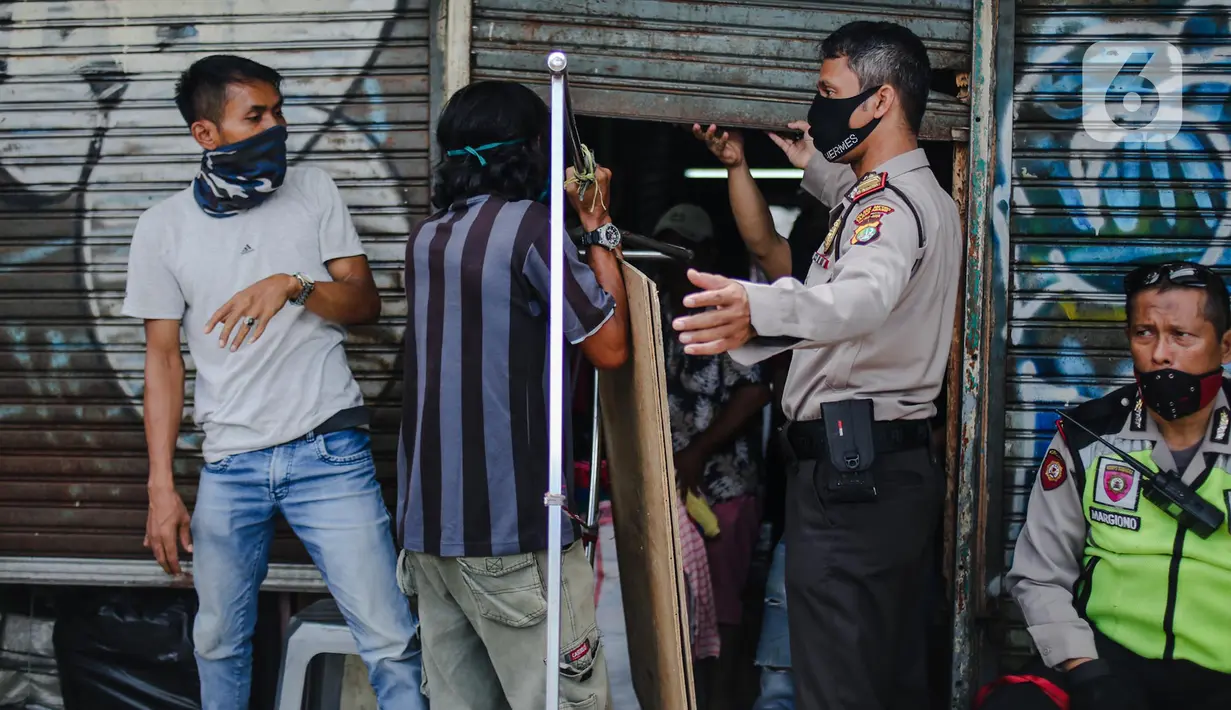 Polisi menertibkan pedagang yang nekat berjualan saat masa pandemi COVID-19 di kawasan Pasar Tanah Abang, Jakarta, Jumat (22/5/2020). Gubernur DKI Jakarta Anies Baswedan menambah PSBB selama 14 hari mulai tanggal 22 Mei 2020. (Liputan6.com/Faizal Fanani)