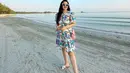OOTD simpel Fitri Carlina liburan di pantai. Ia mengenakan dress berkerah lengan pendek bermotif ramai, simpel memadukannya dengan sandal dan sunglasses dengan frame putih. [Foto: Instagram/fitricarlina]