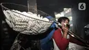 Pekerja mengangkut kerupuk yang telah digoreng di industri rumahan kawasan Cipinang Melayu, Jakarta, Selasa (16/2/2021). Selama pandemi corona, jumlah produksi di industri rumahan ini dikurangi dari 10.000 kerupuk per hari, kini hanya 5.000 kerupuk tiap harinya. (merdeka.com/Iqbal S Nugroho)